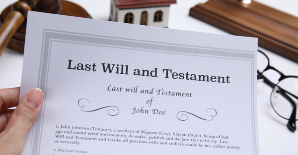 woman holding last will and testament at white table closeup
