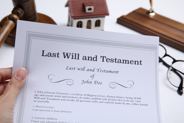 woman holding last will and testament at white table closeup